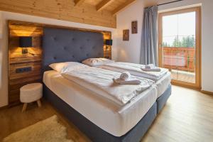 a bedroom with a large bed with a large window at Filzsteinresort Chalets - Chalet 235 in Krimml