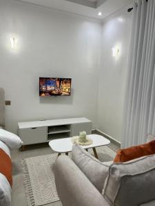 a white living room with a couch and a table at Cozy Homes in Ruaka +24 photos