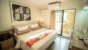 a bedroom with a large white bed and a window at Sawasdee House in Bangkok