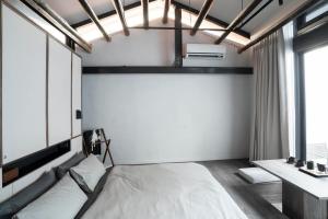 a bedroom with a bed and a window at Sukinab&b喜歡旅居曲巷冬晴 in Lugang