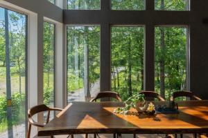 a dining room with a wooden table and large windows at 翠葉 Rusutsu in Rusutsu