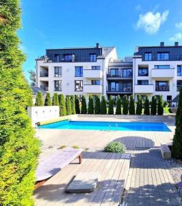een groot gebouw met een zwembad voor een gebouw bij Apartamentai Gintaras in Palanga
