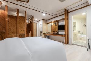 a bedroom with a large bed and a bathroom at Retro Kaohsiung in Kaohsiung