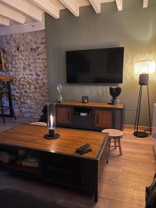 a living room with a flat screen tv on the wall at Maison du bonheur in Combres