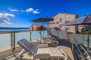 eine Gruppe von Stühlen und Sonnenschirmen auf einer Terrasse in der Unterkunft Villa Ivka in Crikvenica