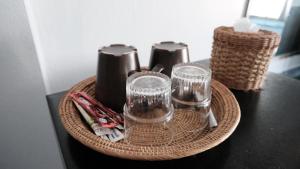 a wicker basket with glasses and utensils on a table at Karon Cove at Seabreeze Inn in Karon Beach