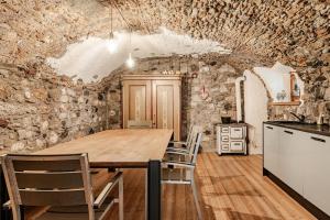 カンポロッソ・イン・ヴァルカナレにあるHeritage Luxury Chalet 1 min from Mt Lussari Ski Liftの木製のテーブルと椅子のあるキッチン