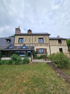 a large house with a yard in front of it at Maison normande au cœur de Le Bec-Hellouin in Le Bec-Hellouin