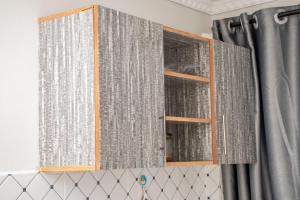 a cupboard with gray curtains in a bathroom at Olmarei Experience Narok, in Narok