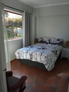 a bedroom with a bed and a chair and a window at Paul's Place in Fisherhaven