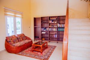 a living room with a couch and a book shelf at Villa Kidege in Accra