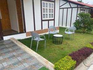 three chairs and a table in a yard at Stay NC Eco Cottages in Nashik