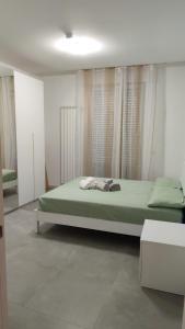 a bedroom with a bed with green sheets and curtains at Il Colle in Azzano Mella