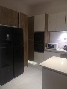 a kitchen with a black refrigerator and a microwave at David Akpo in Lekki