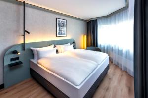 a bedroom with a white bed in a room at Radisson Hotel Düsseldorf City Center in Düsseldorf