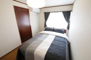 Posto letto in una piccola camera con finestra di Kiryucho House a Takayama