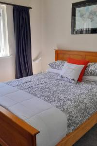 a bedroom with a large bed with a wooden headboard at Spacious 5 bedroom 2 bathroom Home Fast WIFi in Palmerston North
