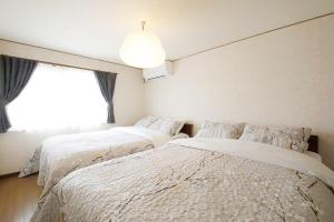 due letti in una camera da letto con finestra di Kiryucho House a Takayama