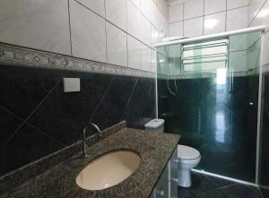 um banheiro com pia e vaso sanitário em Salamaleico Residence - Peruíbe em Peruíbe mais 10 fotografias