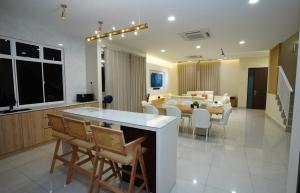a kitchen and dining room with a table and chairs at Desaru 918 Muji Villa in Bandar Penawar