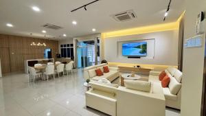 a living room with white couches and a television at Desaru 918 Muji Villa in Bandar Penawar