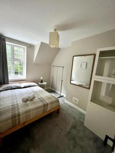 West Byfleetにある3 Bedroom House with Parkingのベッドと大きな窓のある寝室