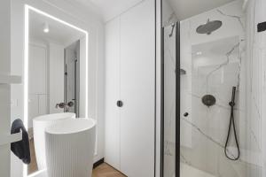 une salle de bain blanche avec une douche et un lavabo dans l'établissement Premium Sky - Apartament przy Enea Stadion Poznań, à Poznań