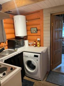 a kitchen with a washing machine and a microwave at Jaundzelves in Stacija )) (( Ozoli +48 photos