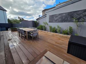 a patio with a table and chairs on a wooden deck at Stylish 6-Bedroom House, Town Centre, Sleeps 14, With Garden in Merthyr Tydfil