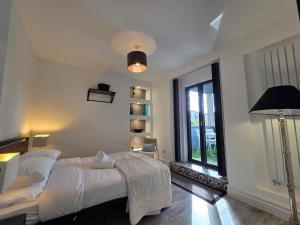 a bedroom with a bed and a large window at Stylish 6-Bedroom House, Town Centre, Sleeps 14, With Garden in Merthyr Tydfil