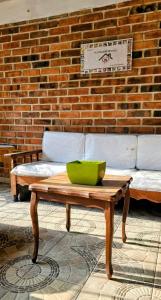 ein Couchtisch vor einer Backsteinwand mit einem Sofa in der Unterkunft El Corazón de Villa in Villa del Carbón