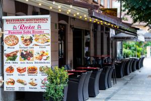 a sign on the side of a restaurant with tables and chairs at Restoran Ruža in Jablanica