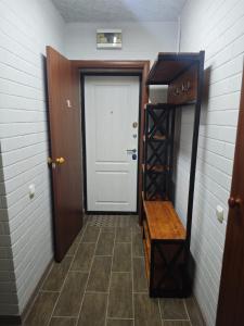 a hallway with a white door and a wooden shelf at Квартира 1 комнатная in Aktau