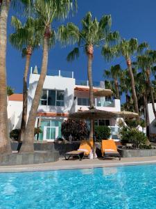a resort with palm trees and a swimming pool at Casa Luna de Luxe, Anlage mit beheiztem Pool, strandnah in Costa Calma