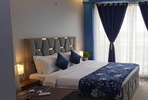 una camera da letto con un grande letto con pareti e finestre blu di Gaur City Studio a Ghaziabad
