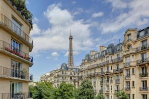 a view of the eiffel tower from between buildings at Champ de Mars & Eiffel Tower -1BR - Paris Vacation Rentals in Paris