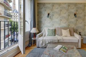 a living room with a couch and a window at Champ de Mars & Eiffel Tower -1BR - Paris Vacation Rentals in Paris