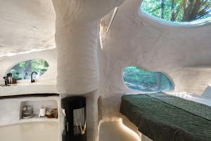 a room with a tub and a bed and a sink at Serenity Lodge in Dragomirna
