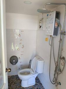 a small bathroom with a toilet and a shower at ภูแสงไฟโฮมสเตย์ in Ban Tai