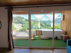 a room with a large sliding glass door with a bath tub at ภูแสงไฟโฮมสเตย์ in Ban Tai