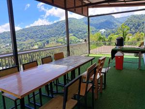 a table and chairs on a balcony with mountains at ภูแสงไฟโฮมสเตย์ in Ban Tai +34 photos