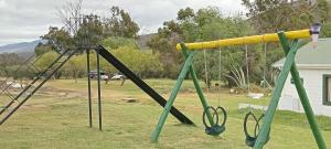 two swings in a yard with at Vaalwater Lodge & Bush Camp in Willowmore