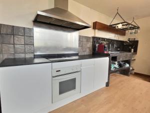 a kitchen with white cabinets and a stove top oven at Jacquemart Hypercentre in Romans-sur-Isère