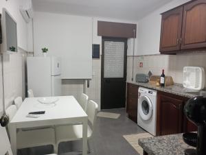 eine Küche mit einem weißen Tisch und einer Waschmaschine in der Unterkunft As Irmãs in Reguengos de Monsaraz