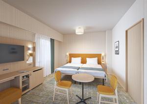 ein Hotelzimmer mit einem Bett und einem Tisch und Stühlen in der Unterkunft Hotel Monterey La Soeur Naha in Naha