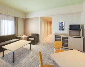 ein Wohnzimmer mit Sofa und Fernseher in der Unterkunft Hotel Monterey La Soeur Naha in Naha