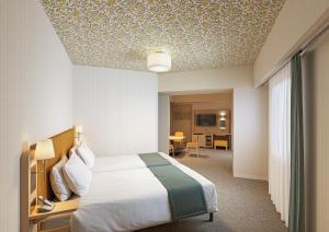 ein Hotelzimmer mit einem Bett und einem Tisch in der Unterkunft Hotel Monterey La Soeur Naha in Naha + 2 Fotos