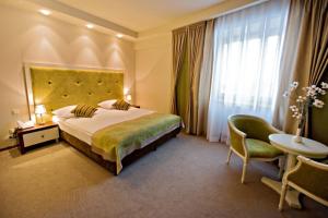 ジェシュフにあるHotel Prezydencki 4-starのベッドと椅子付きのホテルルーム
