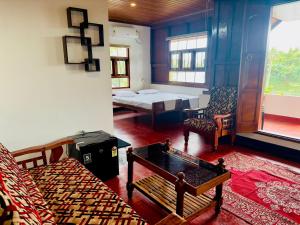 a living room with a bed and a table at Nerayath Nest Homestay in Alleppey