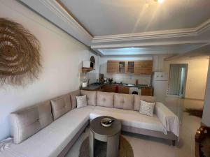 a living room with a couch and a kitchen at chott meriem avec terrasse sur la mer in Chott Meriem